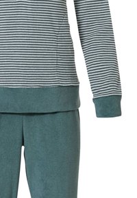 Haut à rayures à manches longues en gris et blanc ; tissu doux et texturé avec une bande bleu-vert en bas. Coordonné avec un pantalon en polaire bleu-vert.