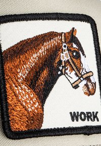 Embroidered patch featuring a brown horse head with white markings, framed in black, with the word "WORK" below on a beige background.