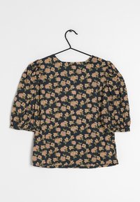 Blusa floreale con maniche a sbuffo, sfondo scuro e motivo di fiori rosa e verdi. Tessuto liscio, scollatura tonda e fit comodo.