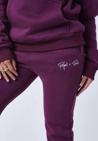 Conjunto de sudadera con capucha y pantalones de chándal en color burdeos, hecho de una mezcla de algodón, con puños y dobladillo acanalados, y bordado del logo en blanco en los pantalones.
