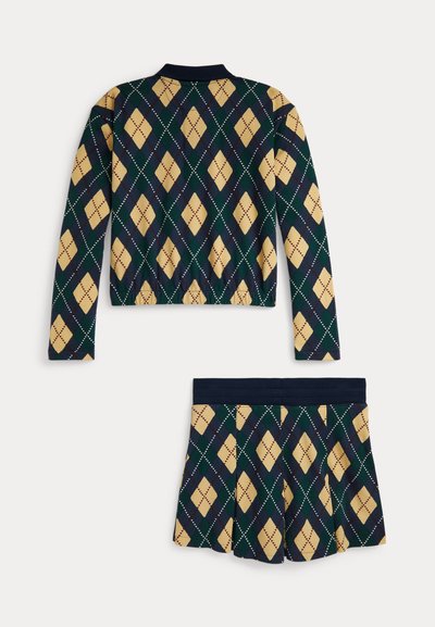 Kötött szett, amely tengerészkék gallérral és szegéllyel, sárga, zöld és tengerészkék gyémántmintával rendelkezik, és pliszírozott szoknyadesign található benne.