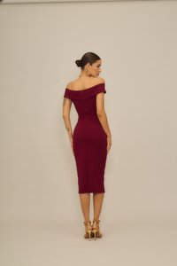 Μπορντό εφαρμοστό φόρεμα με εκτός ώμου λαιμόκοψη και μήκος μέχρι το γόνατο, με υφή υφάσματος και φερμουάρ στην πλάτη. Συνδυασμένο με χρυσά ψηλοτάκουνα σανδάλια με λουράκια.