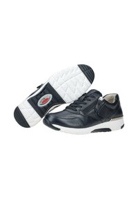 Un par de zapatillas de cuero negro con suelas de goma blanca, cordones, cremallera lateral y suela texturizada con el logo "rollingsoft".