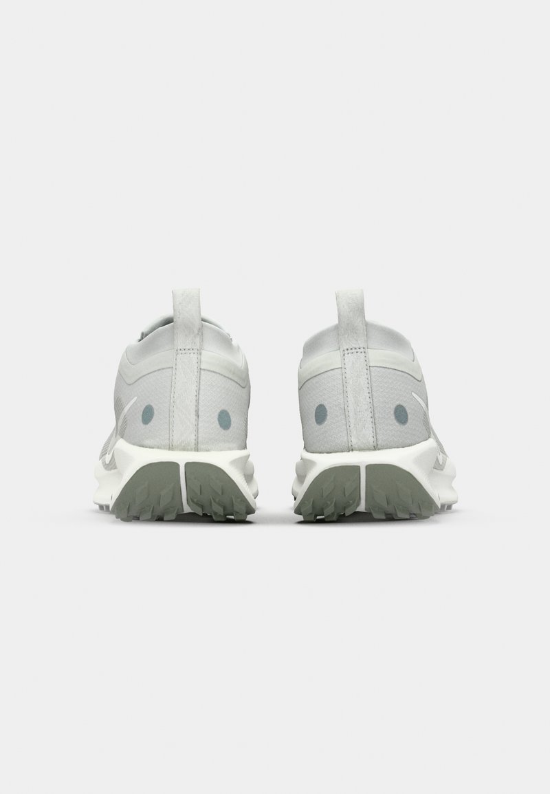 Zapatillas deportivas de color gris claro con un upper texturizado, parte trasera redondeada y suelas de goma estratégicas con patrones de tracción.