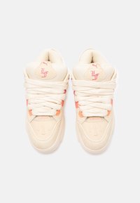 Sneaker beige con accenti rosa, caratterizzati da una parte superiore testurizzata, spesse stringhe bianche e dettagli con logo. Punta arrotondata e collo della caviglia imbottito.