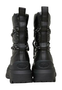 Botas de tobillo acolchadas negras con suela gruesa, que presentan un upper texturizado y cordones blancos contrastantes. Los detalles de la marca están grabados en la parte trasera.