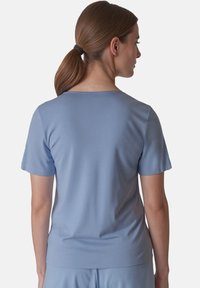 Světlomodrý krátký rukáv tričko s kulatým výstřihem. Hladká textura, přiléhavý styl a jednoduchý design bez vzorů nebo dekorací.