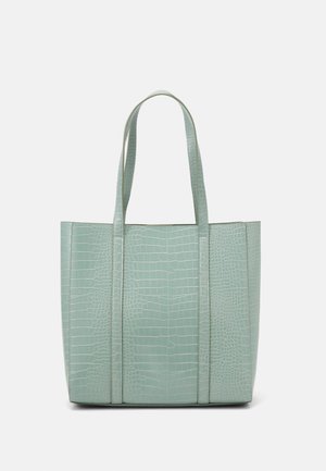 Lichtgroene tote bag met krokodillenstructuur en twee lange handvatten op een effen witte achtergrond.