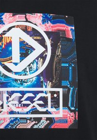 Svart T-shirt med en stor grafisk tryck med blå, rosa och vita abstrakta mönster samt en vit logotyp i centrum.