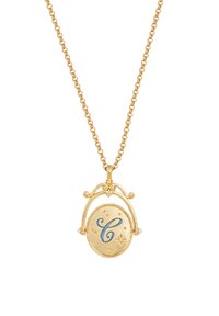 Kultainen kaulakoru koristeellisella ketjulla. Siinä on pyöreä riipus, jossa on sininen kirjain "C" ja tähdistä koristeltuja yksityiskohtia. Koristeltu pienillä helmillä.