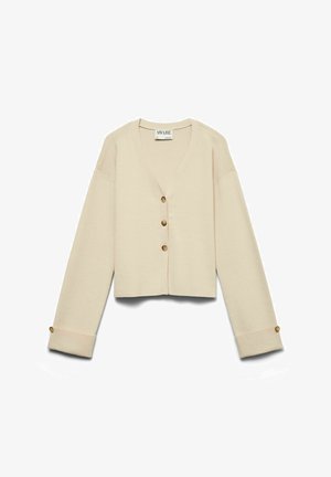 Beige kort cardigan med V-hals, lange ermer og fire brune knapper foran og på mansjettene, laget av strikket stoff.