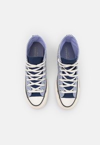 Canvas høytopp-sneakers i marineblå og hvit med stripete mønster, hvite snøringer og gummisåler. Har rund tå og kontrasterende detaljer.