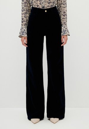 Schwarze Cord-Hosen mit weitem Bein und hoher Taille, mit einem Knopfverschluss vorne und zwei Seitentaschen. Glatte Textur und taillierte Passform.