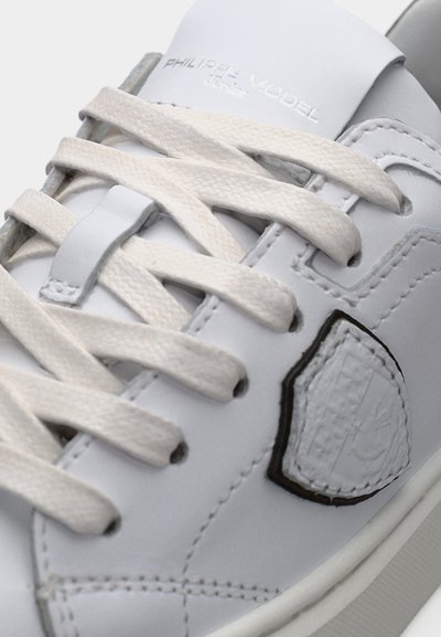 Baskets en cuir blanc avec lacets crème, écusson du logo cousu et "PHILIPPE MODEL" embossé sur la languette.