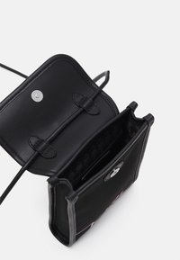 Borsa a tracolla in pelle nera con chiusura a scatto, caratterizzata da un interno strutturato e due scomparti, con tracolle regolabili.