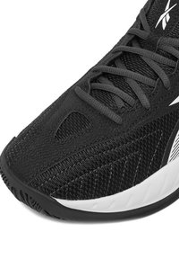 Must spordijalats tekstuuritud võrgust ja sünteetilisest pealsest, millel on valge keskmine tald ja ziggzag-muster külgedel. Paelad ühtivas värvitoonis.