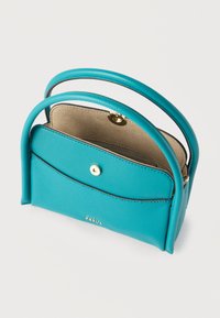 Τυρκουάζ δερμάτινη τσάντα με στρογγυλεμένες λαβές, ανοικτό καπάκι με χρυσό κουμπί και μπεζ εσωτερική επένδυση σε λευκό φόντο.