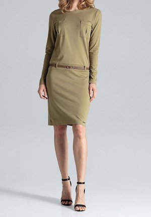 Długa sukienka w oliwkowym kolorze z długim rękawem, dwoma kieszeniami na piersi i brązowym paskiem, o dopasowanym kroju i długości do kolan. Teksturowany materiał.
