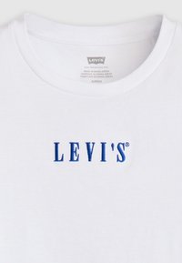 Hvit bomulls T-skjorte med blå brodert "LEVI'S"-logo på fronten, med klassisk rund hals og myk tekstur.