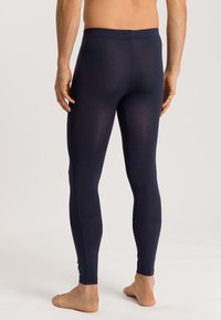 Leggings bleu marine en matériau doux, avec un design ajusté et une taille élastique, texture lisse et longueur chevilles.
