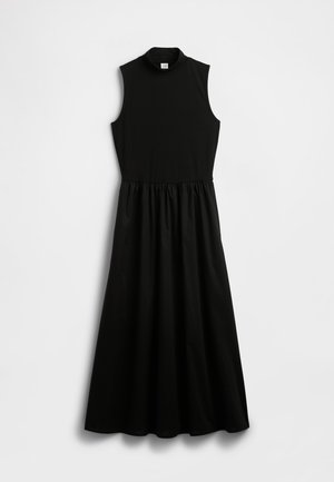 Black sleeveless dress with a mock turtleneck, fitted top, and gathered waist leading to a flowing skirt. Made from a smooth fabric.