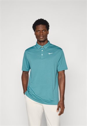 Turkusowa koszulka polo wykonana z oddychającego materiału z teksturowanym wzorem, posiadająca kołnierzyk, trzy guziki i białe logo Nike po lewej stronie klatki piersiowej.