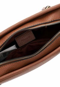 Borsa in pelle marrone con chiusura a zip. All'interno presenta una fodera in tessuto scuro e una piccola tasca testurizzata.