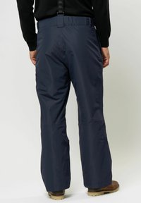 Mörkblå vattentäta skidbyxor med avslappnad passform, justerbar midja och förstärkta benslut, med minimalistisch design och slitstarkt material.