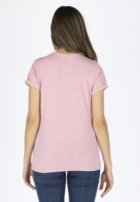 Pink short-sleeve t-shirt with rolled sleeves, round neckline, and soft textured fabric. Back view shows a simple, unembellished design.