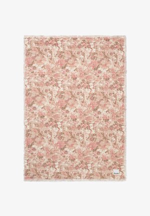 Pehmeä vaaleanpunainen ja beige kukkakuvioinen vauvan viltti, jossa on teksturoitu kangas ja Elodie-merkkinen tunniste kulmassa.