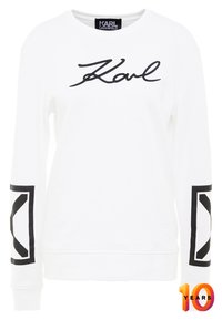 Felpa bianca con logo "Karl" nero sul davanti e design geometrico nero sulle maniche. Realizzata in tessuto morbido, con colletto arrotondato.