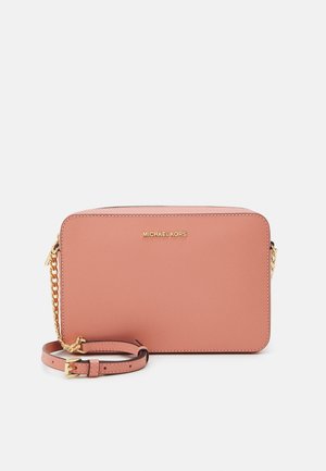 Prostokątna różowa torebka listonoszka z skóry z złotym łańcuszkowym paskiem oraz logo MICHAEL KORS na przodzie, na białym tle.