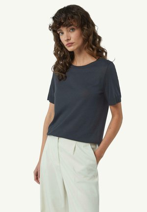Donkergrijze kortegalm t-shirt met een ronde hals, gemaakt van zachte stof, gecombineerd met hooggepaste lichtgekleurde broek.