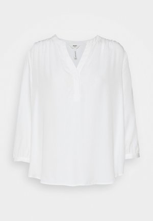 Blouse blanche ample avec manches 3/4, petit col montant et patte de boutonnage devant, en tissu léger.