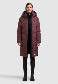 Burgundipunane polsterdatud mantel kapuutsi ja esika saab kinnitada tõmbluku ning pressnuppudega, tekstuurse kangaga ja alumisel äärel asuva logomärgiga.