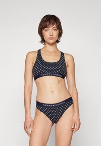 Marineblauwe katoenen sportbeha en bijpassende bikinionderkant met sterrenpatronen en een contrasterende elastische band met het "TOMMY HILFIGER" logo.
