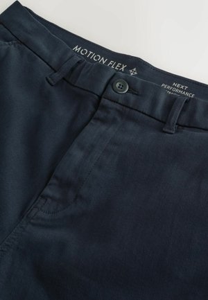 Námornícke nohavice vyrobené z flexibilného materiálu. Majú zapínanie na gombík, predné vrecká a jemnú textúru. Vyšívaná značka na páse.