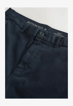 Merikarhupaidat, jotka on valmistettu joustavasta materiaalista. Ominaisuuksiin kuuluvat napitus suljenta, etutaskut ja sileä pinta. Brodeerattu brändäys vyötäröllä.