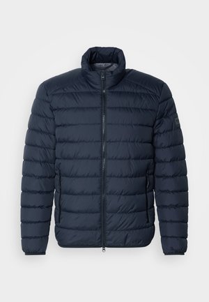 Tumedasinine puff-jakk, millel on horisontaalne õmblus, kõrge krae, eeslane tõmblukk ja tõmblukkude küljetaskud. Valmistatud kergest, isoleeritud materjalist.