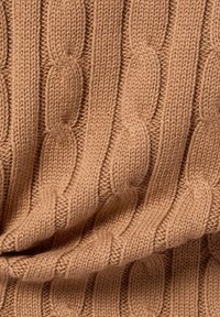 Sweter dziewiarski w miękkim brązowym kolorze, z wyraźnym grubym wzorem warkocza i fakturą. Materiał wydaje się ciepły i elastyczny, z widocznymi ściegami.