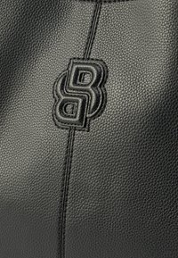 Fekete, texturált bőr kézitáska kiemelkedő logóval és kontrasztos varrással. A dizájn sima, díszített varratokkal egészül ki.