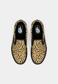 Slip-on Vans tenisice s uzorkom smeškastog leopardovog uzorka u bež i crnoj boji, prikazane odozgo na beloj pozadini.