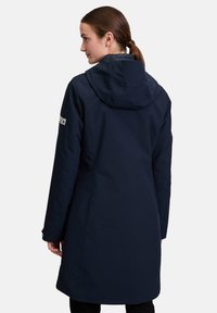 Navy waterproof parka with a hood, featuring a zipper closure and a slightly longer back hem, made of smooth, lightweight fabric.
