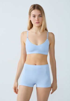 Ensemble de soutien-gorge et short bleu clair en tissu doux. Le soutien-gorge possède des bretelles fines et une finition lisse, tandis que le short a une taille élastique.