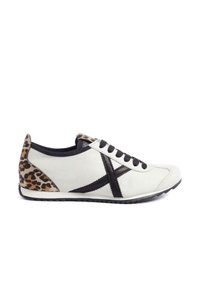 Białe trampki z czarnymi sznurówkami, z akcentem w panterkę na pięcie i czarnym wzorem X po boku. Gładka skóra.