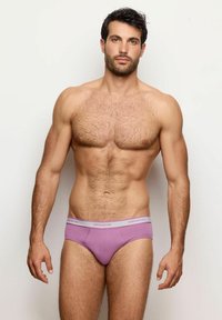 Slip in cotone lilla con una morbida texture, dotati di un elastico grigio in contrasto con la scritta "yamamay". Il modello posa frontale, mostrando la vestibilità.