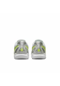Sport shoes with a silver upper, neon green accents, and a textured white sole. Features a padded collar and logo detail on the heel.