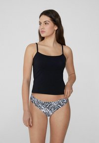 Černý těsný top na tenké ramínka v kombinaci s černobílými bikinami se zebřím vzorem. Hladká látka s kontrastními detaily.