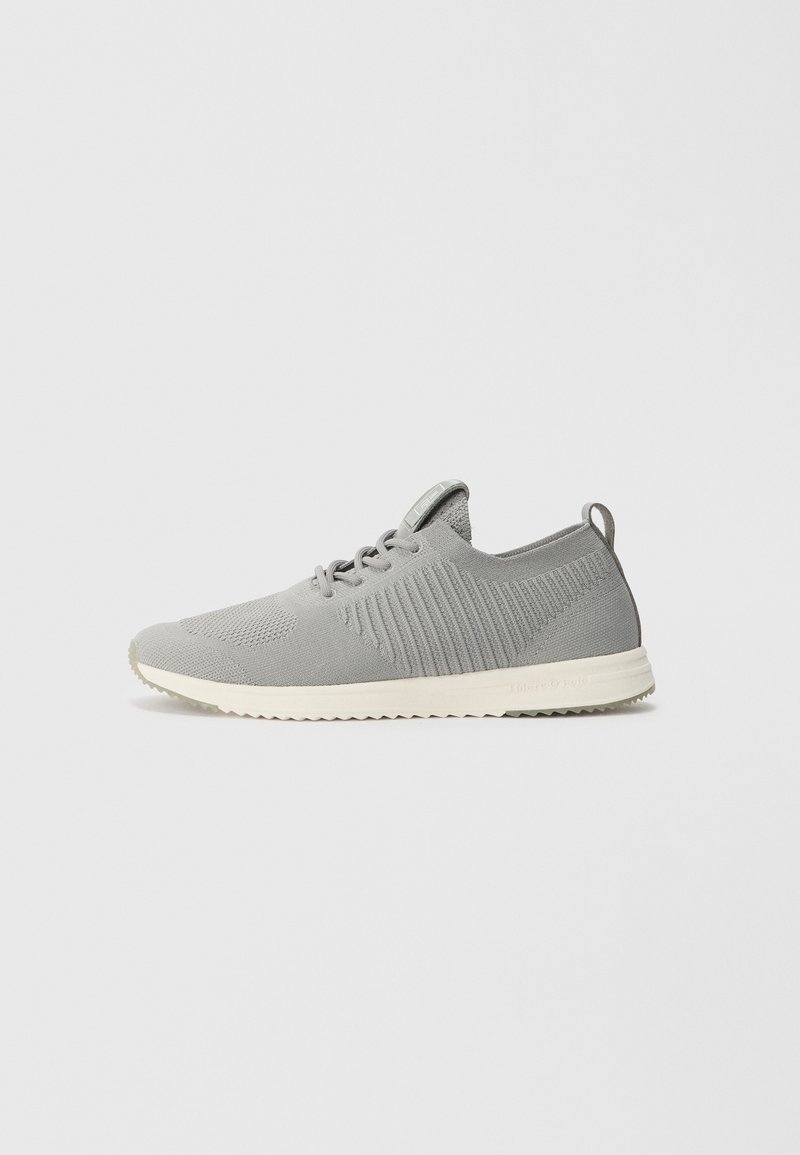 Baskets de sport gris clair avec une tige en maille, un design à côtes et une semelle crème contrastante. Elles disposent de lacets ronds et d'une languette au niveau du talon.