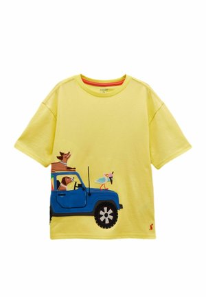 Žltá krátkos rukávová košeľa s modrým obrázkom auta, ktoré viezie dva psy a vtáka držiaceho kornútok s zmrzlinou na kapote.